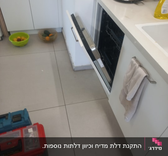 מדיח כלים פתוח עם כלי עבודה על הרצפה